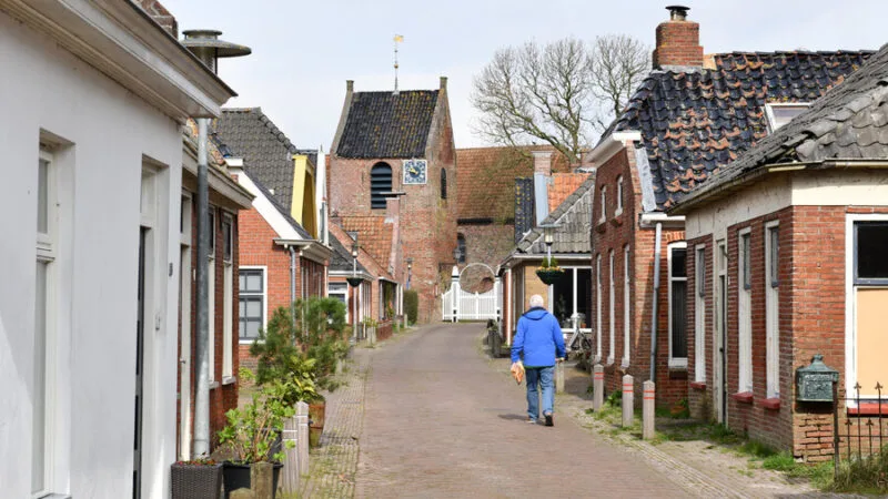 Een wandelaar in dorp Ezinge