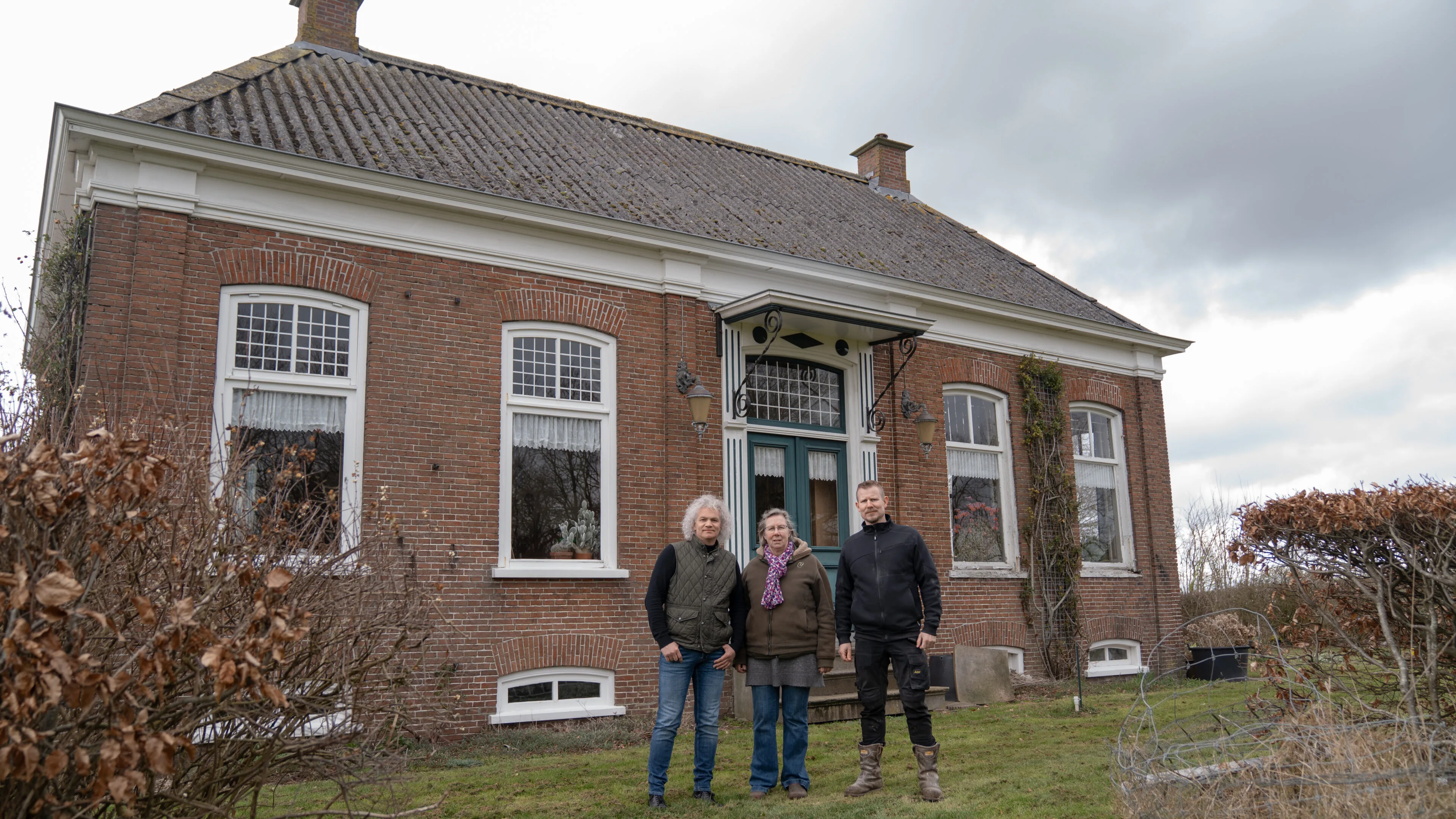 Agroconsulent helpt boeren en poseert met hen voor hun boerderij