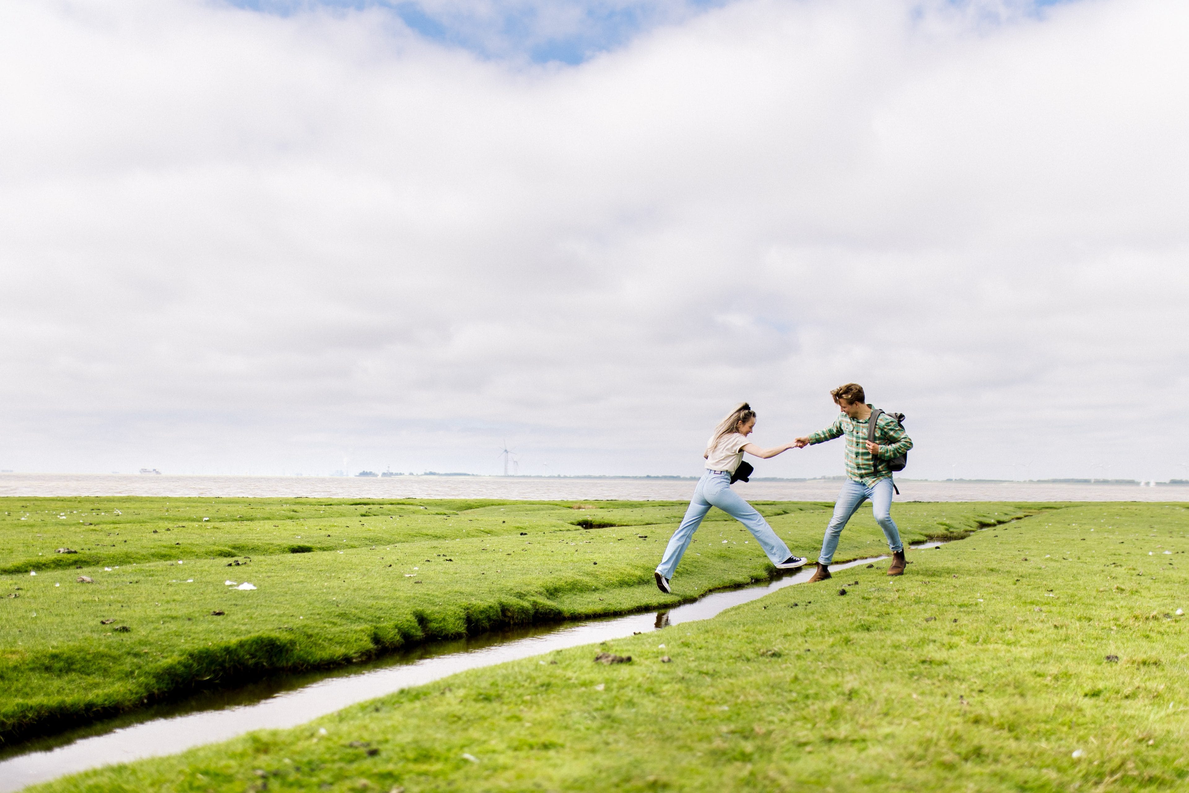 Jongeren springen over sloot