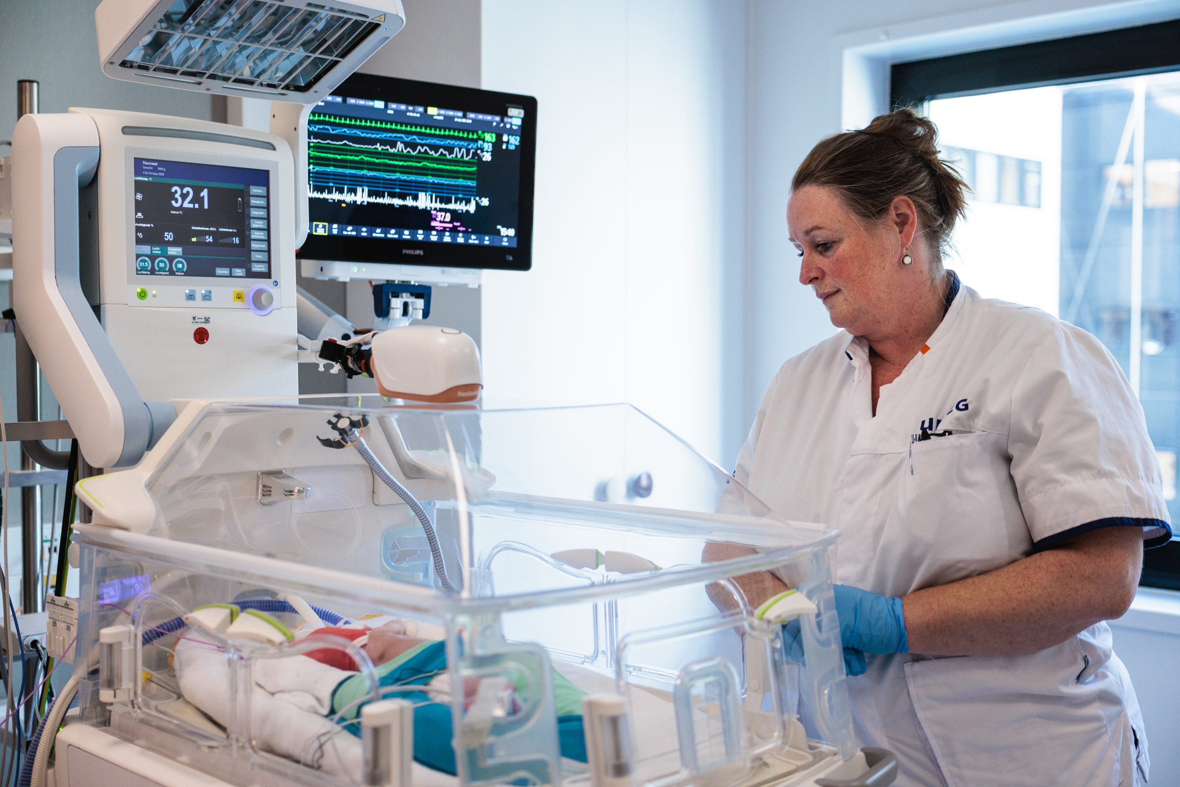 Verpleegkundige bij baby in couveuse in ziekenhuis