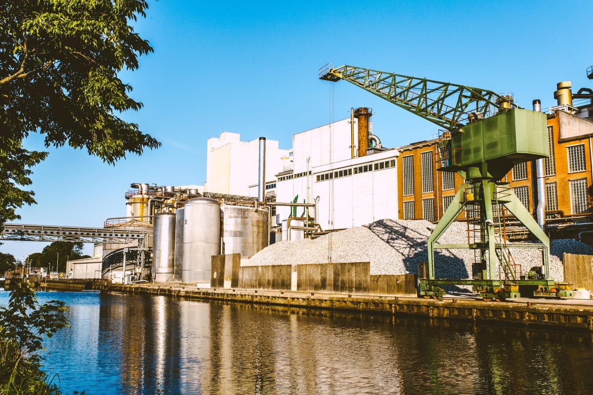 Suikerfabriek aan het water met hijskraan