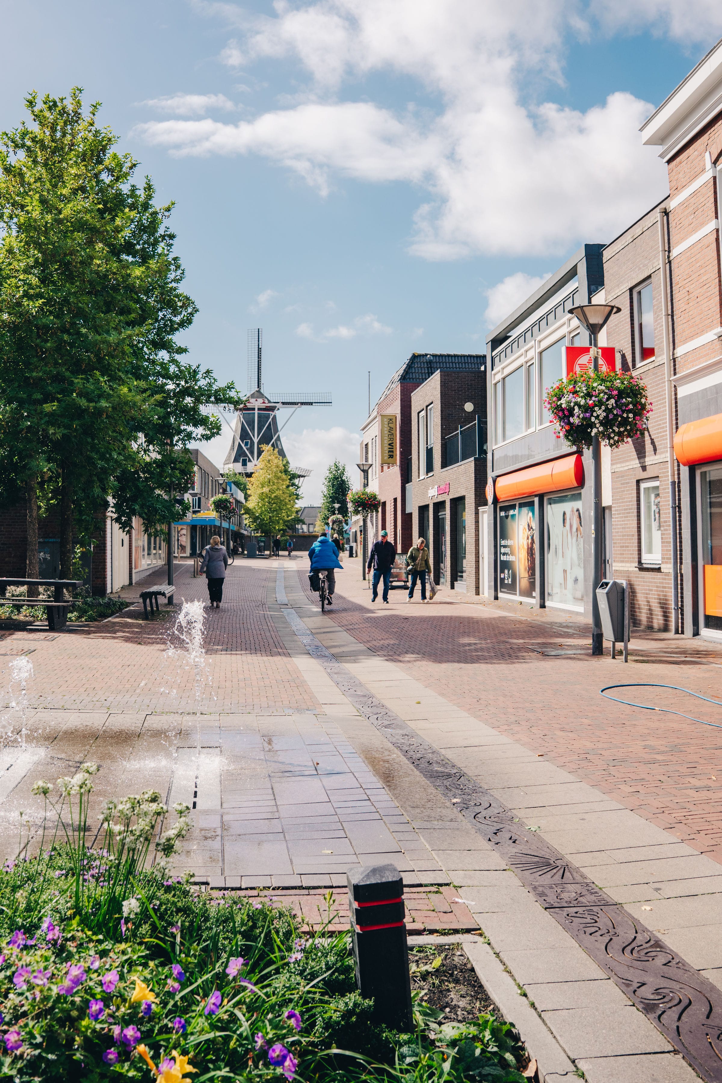 Winkelstraat in Delfzijl met wandelaars en fietsers in de verte