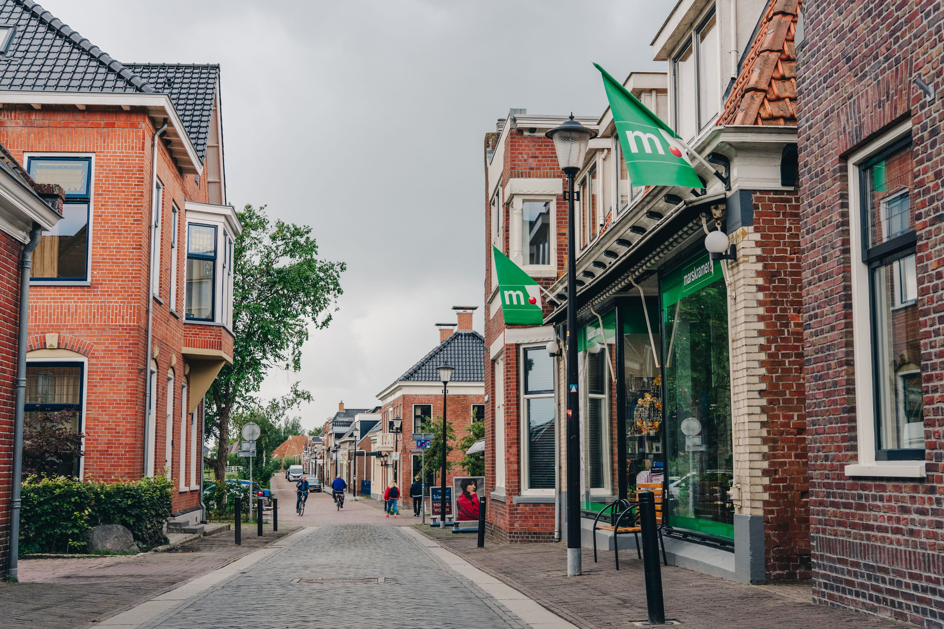 Winkelstraat in Loppersum met wandelaars en fietsers in de verte