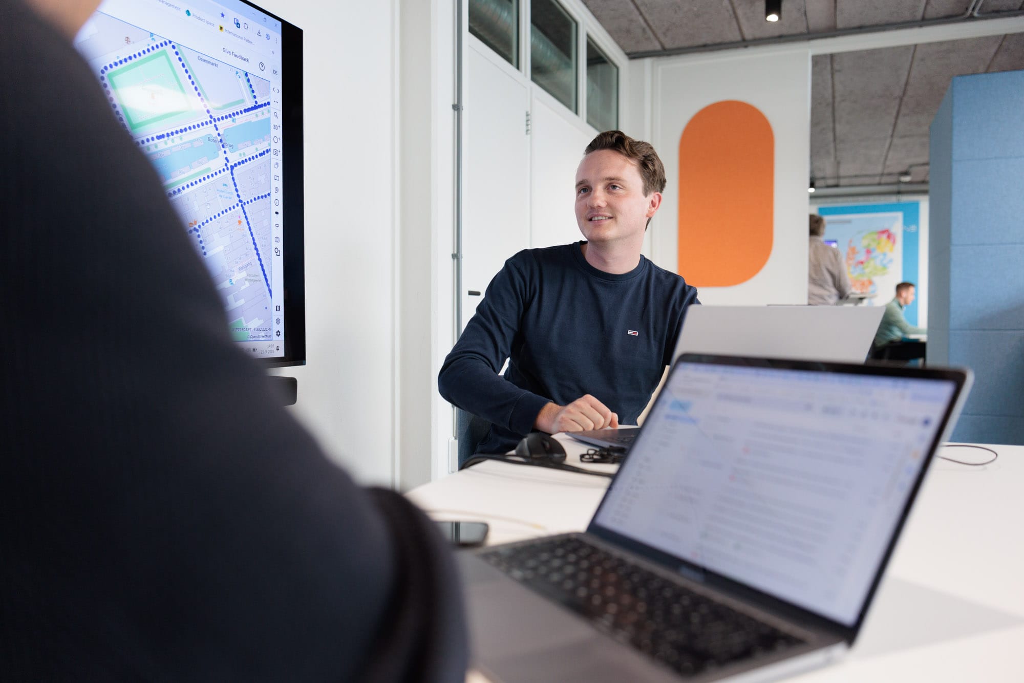 Twee personen in gesprek bij een laptop