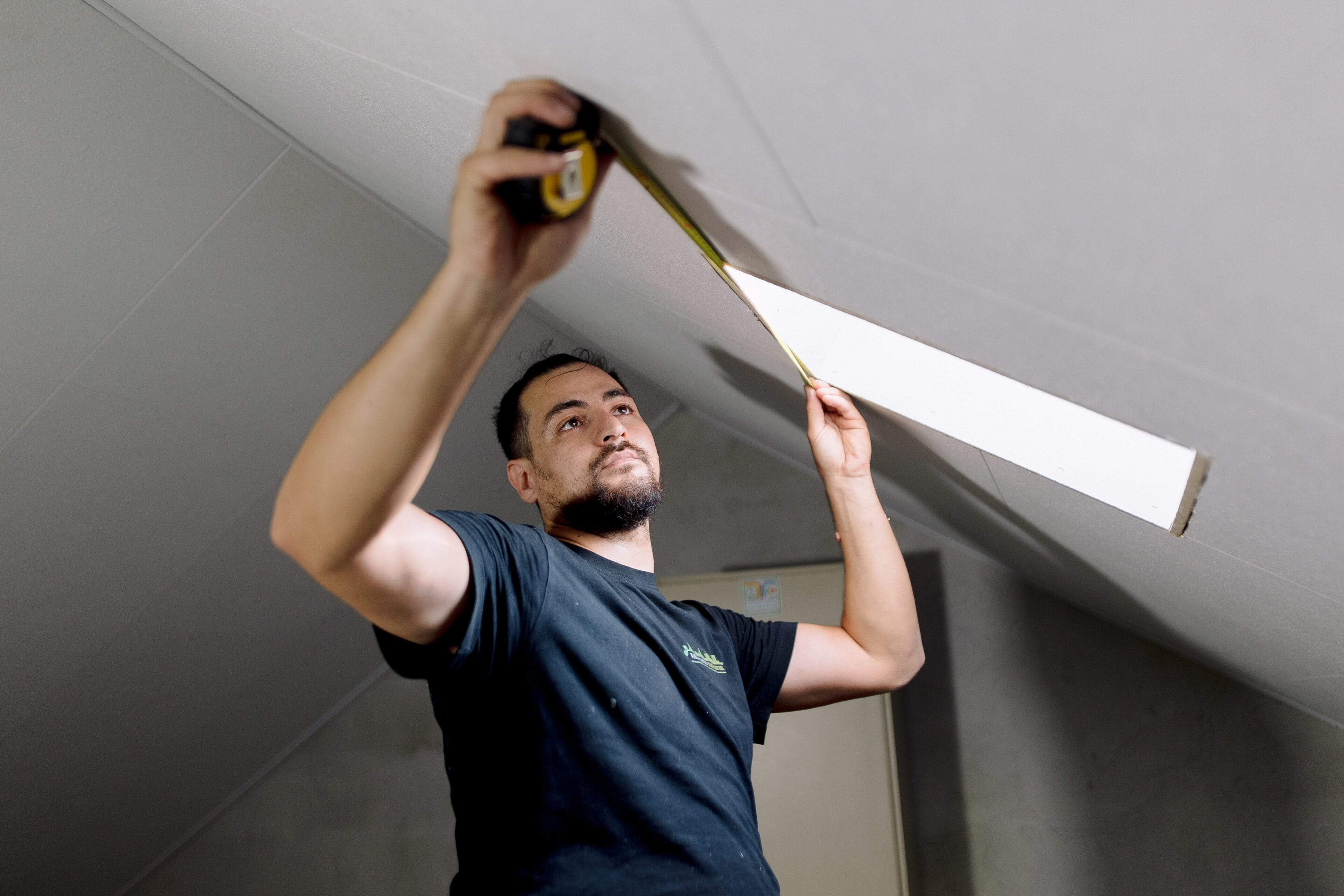 Isolatiemedewerker meet platen van het dak op van binnenuit
