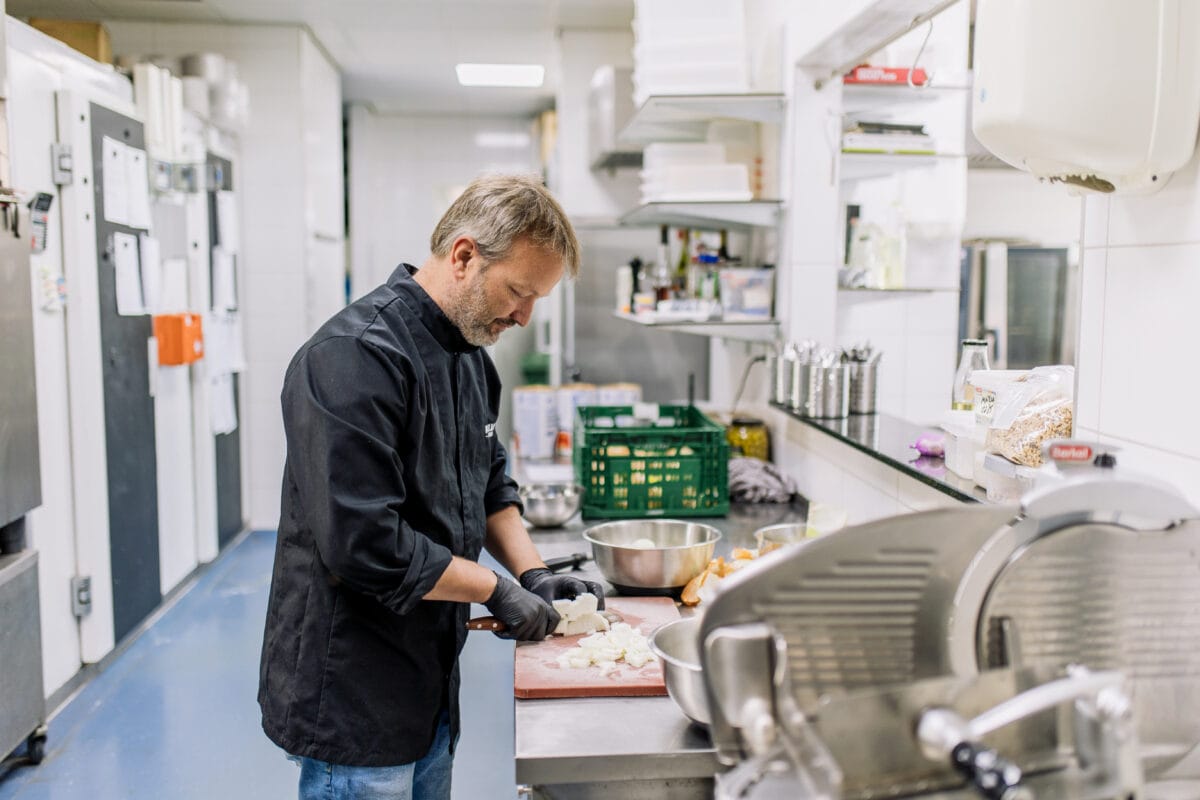 Kok (ondernemer) die eten aan het bereiden is.