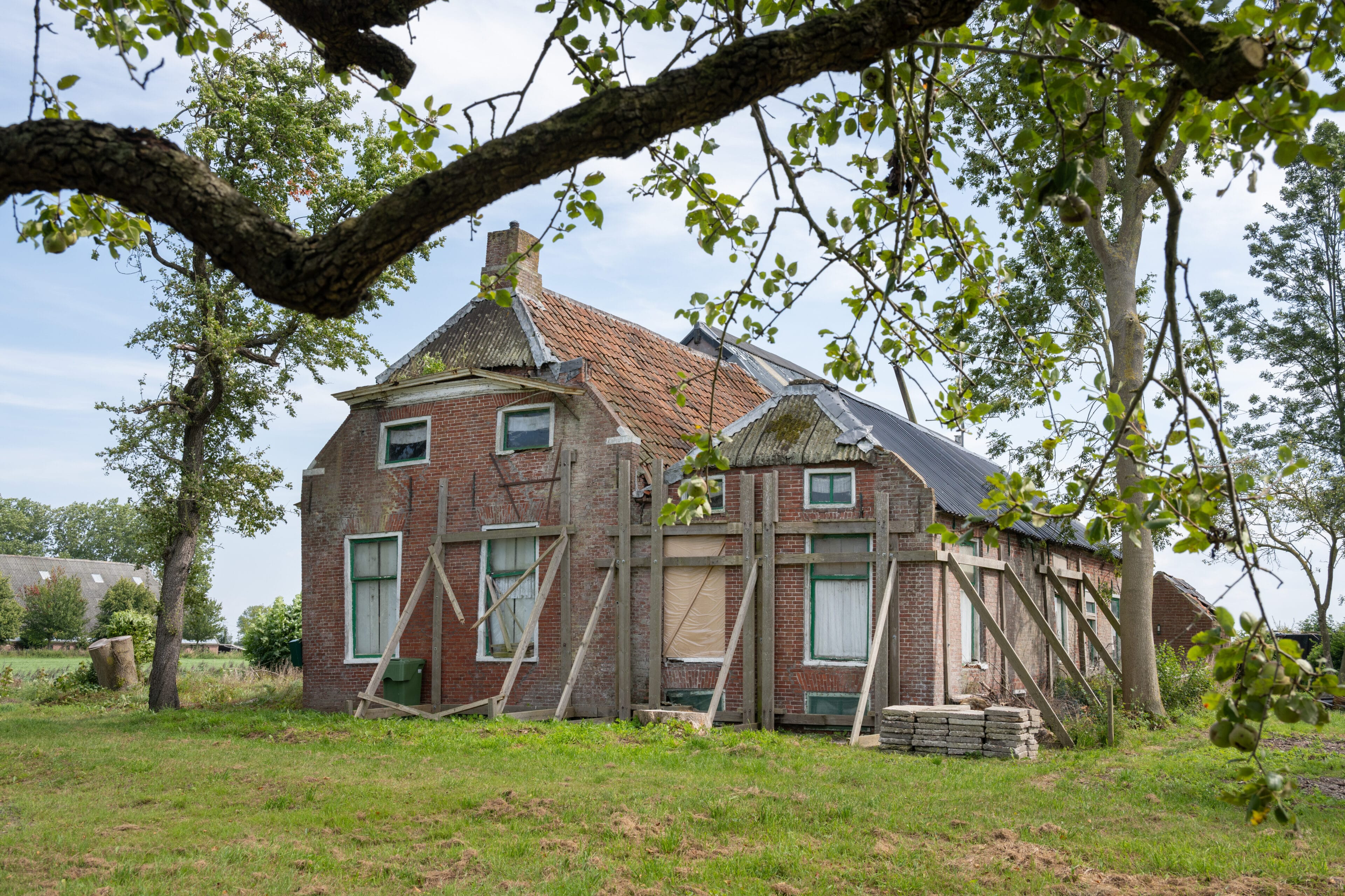Een huis in de steigers door hestelwerkzaamheden door de gevolgen van de gaswinning.